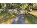 Long driveway leading to the property with mature trees and natural landscaping at 6700 Nw 57Th Ave, Ocala, FL 34482