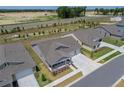 An aerial view of a well-maintained home featuring a three-car garage, landscaping, and proximity to a roadway at 7687 Sw 63Rd Place Rd, Ocala, FL 34474