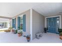Inviting front porch with blue front door, bench, nice plants and blue shutters provide a perfect curb appeal at 7687 Sw 63Rd Place Rd, Ocala, FL 34474