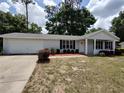 Single-story home with an attached garage, front porch, and tidy landscaping at 8045 Sw 108Th Loop, Ocala, FL 34481