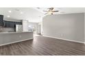 Open-concept living room featuring vaulted ceilings, modern ceiling fan, and wood-look flooring at 87 Guava Pass Dr, Ocklawaha, FL 32179