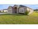 Well-maintained front yard showcases lush green grass and landscaping, enhancing the home's curb appeal at 9074 Se 48Th Court Rd, Ocala, FL 34480