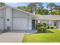 Inviting single-story home with an attached garage, featuring lush green lawn and a cozy entrance at 10441 Sw 85Th Ct, Ocala, FL 34481