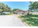 Well maintained house exterior with a three car garage, paver driveway and manicured lawn at 1213 Meadowbend Dr, Leesburg, FL 34748