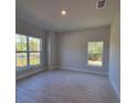 Neutral bedroom showcasing tile floors, recessed lighting, and two windows at 13154 Sw 69Th Ct, Ocala, FL 34473