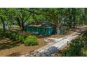 Charming single-story home with mature trees, a grassy yard, and a long driveway that adds to the property's appeal at 14190 Ne 209Th Ct, Fort Mc Coy, FL 32134