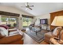 Bright living room featuring a ceiling fan, sliding glass doors and wood-look floors at 15426 Sw 14Th Avenue Rd, Ocala, FL 34473