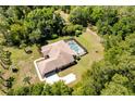 An elevated view showcasing the enclosed pool and verdant, tree-lined property at 21939 Sw 85Th Loop, Dunnellon, FL 34431