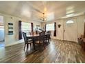 Well-lit dining room featuring wood floors, a chandelier, and a dining table with seating for six at 25292 Ne 132Nd Ln, Fort Mc Coy, FL 32134