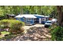 Bright blue house with a metal roof, wood porch, and parking for multiple cars on a sunny day at 25292 Ne 132Nd Ln, Fort Mc Coy, FL 32134