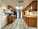 Spacious kitchen featuring wooden cabinets, black appliances, and a skylight for natural light at 25292 Ne 132Nd Ln, Fort Mc Coy, FL 32134