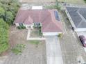 An aerial view showcasing a home's roof with solar panels, surrounded by a landscaped yard and neighboring houses at 2730 Sw 162Nd Street Rd, Ocala, FL 34473