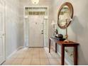 Bright foyer with tile flooring, a decorative mirror, and a view of the front door at 4424 Se 14Th St, Ocala, FL 34471