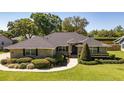 An appealing single-story home featuring a well-maintained lawn, mature trees, and manicured shrubbery at 4424 Se 14Th St, Ocala, FL 34471
