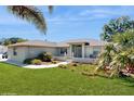 Lovely single-story home with manicured lawn, mature palm trees, and walkway to gated front entry at 4716 Nw 34Th Pl, Ocala, FL 34482