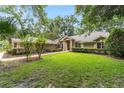 Well-maintained single-story home with lush green lawn and mature trees, creating a serene and inviting setting at 733 Se 67Th Ln, Ocala, FL 34480