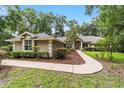 Charming single-story home with manicured lawn and inviting walkway, surrounded by mature trees and lush landscaping at 733 Se 67Th Ln, Ocala, FL 34480