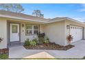 Charming home featuring a well-manicured lawn, fresh landscaping, and a neatly painted garage and entryway at 77 Locust Dr, Ocala, FL 34472
