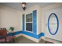 Charming entryway with colorful accents, including a blue-trimmed window and door, plus a comfortable chair at 8990 Se 155Th Pl, Summerfield, FL 34491