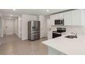 Modern kitchen with stainless steel appliances, white countertops, and ample storage space at 13032 Sw 84Th Terrace Rd, Ocala, FL 34473