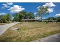 Single-story home with mature trees, long driveway, and well-maintained front lawn at 164 Ne 53Rd St, Ocala, FL 34479