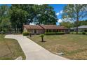 A well-kept single-story home on a spacious lot featuring a paved driveway, mature trees and a brick facade at 164 Ne 53Rd St, Ocala, FL 34479