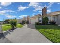 Street view of the home featuring an attached garage, landscaping, and brick chimney at 2343 Se 19Th Cir, Ocala, FL 34471