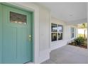 Inviting front door with a teal finish, framed by white trim and a charming porch area at 3 Redwood Track Run, Ocala, FL 34472