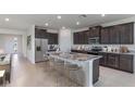 Spacious kitchen island with seating, granite countertops, and stainless-steel appliances at 3059 Canopy Oak Blvd, Wildwood, FL 34785