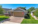 View of the home's front exterior, showcasing a brick driveway leading to a two-car garage at 3918 Nw 46Th Ter, Ocala, FL 34482