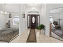 Spacious foyer with tile flooring, featuring a decorative rug leading to the main entrance door at 4085 Sw 110Th St, Ocala, FL 34476