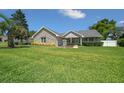 Charming single-story home featuring a stone facade, lush green lawn, and well-manicured landscaping at 4401 Sw 44Th Ln, Ocala, FL 34474