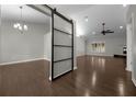 Bright living room featuring a modern sliding barn door, hardwood floors, and contemporary lighting at 4401 Sw 44Th Ln, Ocala, FL 34474