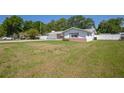 Single-story home with white fencing, a well-maintained lawn, and a side entry garage at 4810 County Road 114, Wildwood, FL 34785