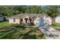 Charming single-Gathering home featuring a manicured lawn and an attached two-car garage at 5900 Nw 61St Ct, Ocala, FL 34482