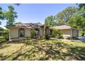 Well-maintained home showcasing a lush lawn, arched windows, and a side-entry garage at 6150 Nw 59Th Ave, Ocala, FL 34482