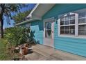 Quaint turquoise home showcasing the front door with surrounding landscape and clear, bright windows at 731 Cloverleaf Blvd, Deltona, FL 32725