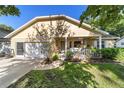 Charming home featuring a covered front porch, attached garage, and lush lawn at 9153 Sw 83Rd Ter # E, Ocala, FL 34481