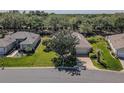 Aerial view of single-story home with a lush lawn, mature trees, and proximity to neighboring properties at 9325 Se 132Nd Pl, Summerfield, FL 34491