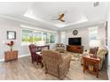 Bright living room featuring hardwood floors, tray ceiling, and large windows at 9573 Sw 79Th Loop, Ocala, FL 34481