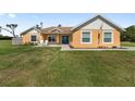 Charming one-story home featuring a vibrant yellow exterior and well-manicured front lawn at 9950 Nw 11Th Ter, Ocala, FL 34475