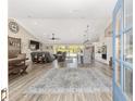 Open-concept living space features wood floors, recessed lighting, and a seamless flow to the kitchen and outdoor area at 9950 Nw 11Th Ter, Ocala, FL 34475