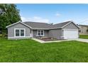 Charming single-story home with a well-manicured lawn and a two-car garage under a bright blue sky at 12 Oak Circle Pass, Ocala, FL 34472