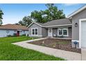Inviting single-story home with a well-manicured lawn and a walkway leading to the front door at 12 Oak Circle Pass, Ocala, FL 34472