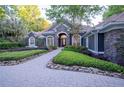 Charming home featuring stone accents, arched windows, and a beautifully landscaped front yard at 1450 Se 73Rd Pl, Ocala, FL 34480