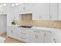 Close-up of kitchen with white cabinets, granite countertops, and modern cooktop creating a sleek cooking area at 1784 Nw 85Th Loop, Ocala, FL 34475