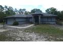 Single-story home featuring stone accents, arched windows, and lush surroundings at 20364 Sw 86Th Loop, Dunnellon, FL 34431