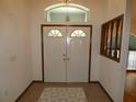 Inviting entryway featuring double doors, tile flooring, and an elegant chandelier at 20364 Sw 86Th Loop, Dunnellon, FL 34431