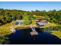 Scenic aerial view of waterfront homes, private dock, pontoon boat, and serene lake setting at 23800 Ne 190Th St, Fort Mc Coy, FL 32134