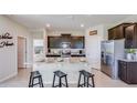 Open kitchen featuring dark cabinets, a granite countertop island with seating, and stainless steel appliances at 4050 Nw 48Th Terrace Rd, Ocala, FL 34482